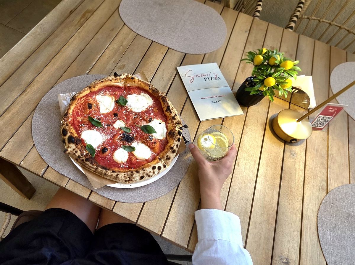 Masă cu pizza Sami's, meniu și o băutură, văzută de sus